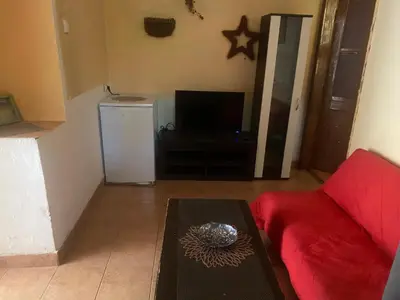 a living room with a red couch and a television at Apartments OldTown in Podgorica