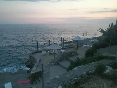 a view of the ocean with chairs and umbrellas at Apartmani Seaside in Dobra Voda