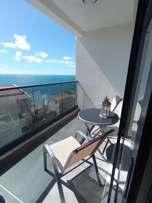 a balcony with a table and a view of the ocean at Apartmani Seaside in Dobra Voda