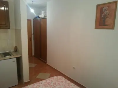 a kitchen with a white wall and a refrigerator at Apartments Nurkovic in Dobra Voda