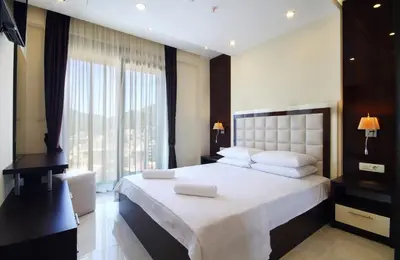 a bedroom with a large bed and a large window at Shine residence in Budva