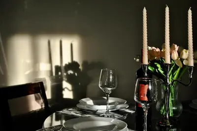 a table with plates and glasses and a bottle of wine at Shine residence in Budva