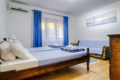 a bedroom with a bed with blue curtains at Pavle's Oasis in Virpazar