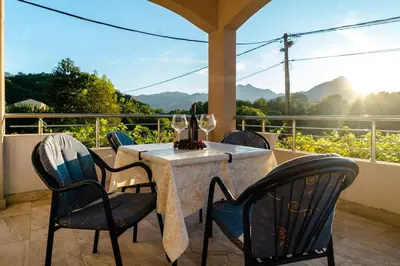 a table with chairs and wine glasses on a patio at Pavle's Oasis in Virpazar
