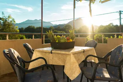 a table with chairs and a bowl of fruit on a balcony at Pavle's Oasis in Virpazar