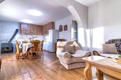 a kitchen and living room with a table and chairs at Pavle's Oasis in Virpazar