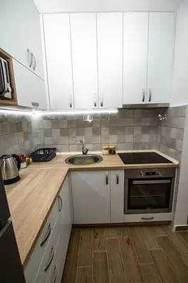 a kitchen with white cabinets and a sink at Milan apartment in Bar