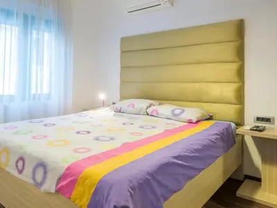 a bedroom with a large bed with a large headboard at Apartments Windrose in Kotor