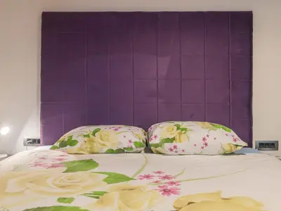 a bed with two pillows and a purple headboard at Apartments Windrose in Kotor