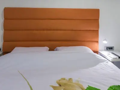 a large white bed with an orange headboard at Apartments Windrose in Kotor