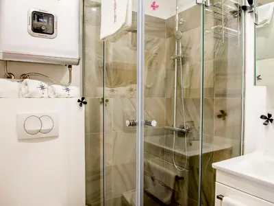 a shower with a glass door in a bathroom at Apartments Windrose in Kotor