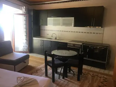 a kitchen with black cabinets and a table and chairs at Guest House Alea in Ulcinj