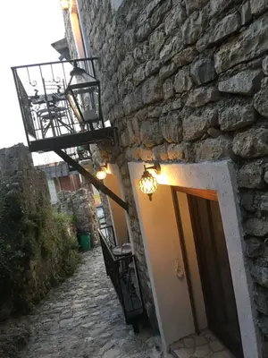 a stone building with a door and a fire hydrant at Guest House Alea in Ulcinj