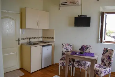 a kitchen with a sink and a table and chairs at Guest House Alea in Ulcinj