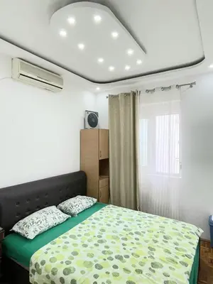 a bedroom with a bed with a green comforter at Centro apartments and rooms in Ulcinj
