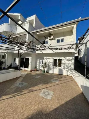 a large white building with a courtyard in front of it at Centro apartments and rooms in Ulcinj