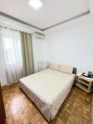 a bedroom with a white bed and a window at Centro apartments and rooms in Ulcinj