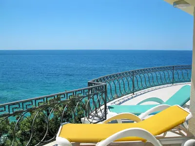 a balcony with chairs and the ocean in the background at Villa Yukka in Utjeha