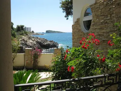 a view of the ocean from a house with red flowers at Villa Yukka in Utjeha