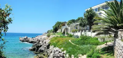 a building on a cliff next to the ocean at Villa Yukka in Utjeha