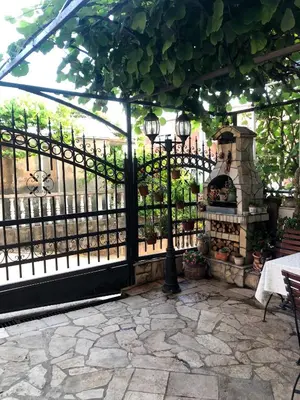 a pergola with a stone patio with a heater at Apartments Moracanin in Sutomore