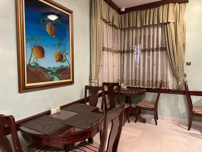 a dining room with a table and chairs and a painting at Beatrix Lux Hotel in Budva