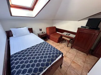 a bedroom with a bed and a chair and a desk at Beatrix Lux Hotel in Budva