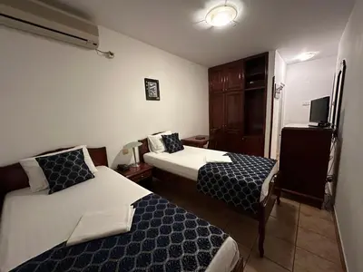 a hotel room with two beds and a tv at Beatrix Lux Hotel in Budva