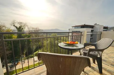 a balcony with a table with a bowl of fruit on it at KM Apartments in Kotor