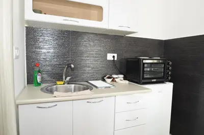 a kitchen with a sink and a microwave at KM Apartments in Kotor