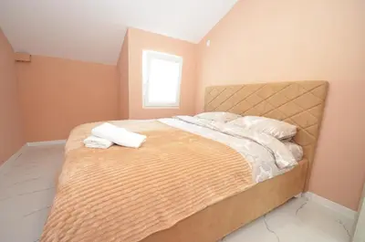 a bedroom with a bed with two towels on it at KM Apartments in Kotor