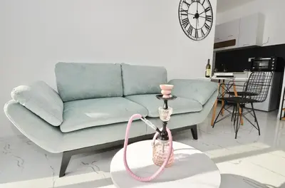 a living room with a blue couch and a pink hose at KM Apartments in Kotor