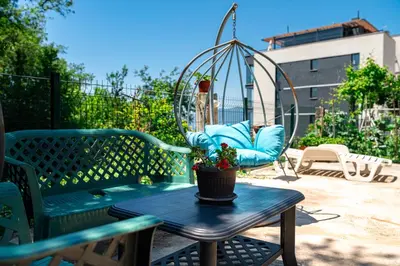 a patio with a bench and a swing and a table at KM Apartments in Kotor
