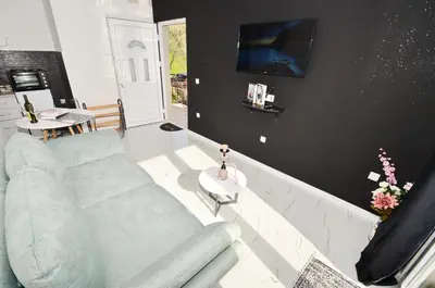 a living room with a blue couch and a tv at KM Apartments in Kotor