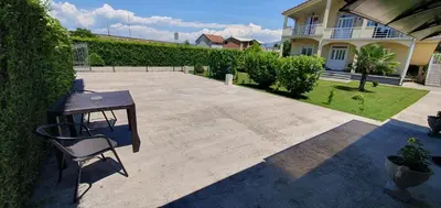 a patio with a table and a chair in front of a house at Cozzy apartment near the Aiport Podgorica in Mitrovići