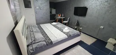 a bedroom with a bed and a tv in a room at Cozzy apartment near the Aiport Podgorica in Mitrovići