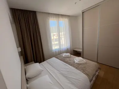 a bedroom with a white bed and a window at Seabreeze apartments Budva in Budva