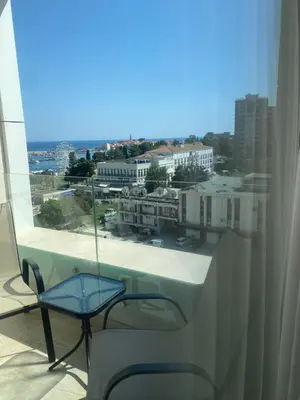 a balcony with a chair and a view of a city at Seabreeze apartments Budva in Budva