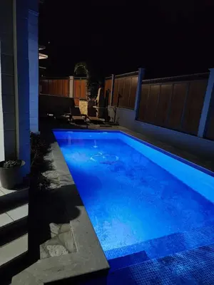 a swimming pool at night with blue water at Sunny Villa in Kavac in Tivat