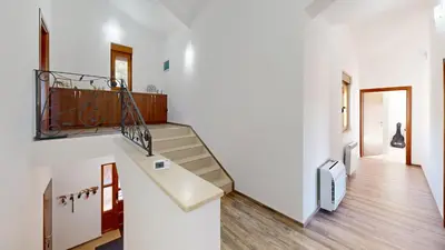 a staircase in a home with white walls and wooden floors at Sunny Villa in Kavac in Tivat