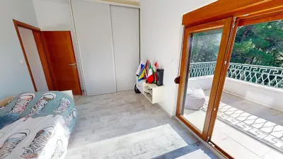 a bedroom with a bed and a balcony with a window at Sunny Villa in Kavac in Tivat