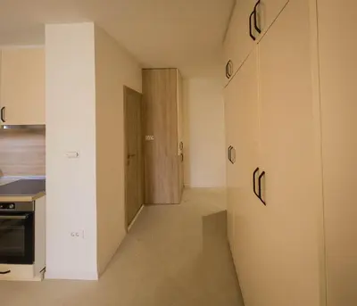 a room with a hallway with a door and a kitchen at SereneHaven in Kotor