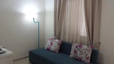 a blue couch with two pillows in front of a window at Apartments Fortunella in Budva