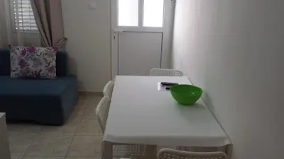 a white table and chairs with a green bowl on it at Apartments Fortunella in Budva