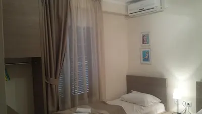 a bedroom with a bed and a window with a curtain at Apartments Fortunella in Budva