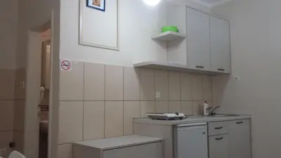 a small kitchen with white cabinets and a sink at Apartments Fortunella in Budva