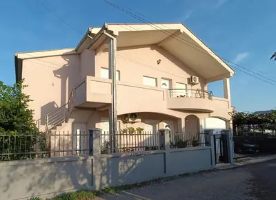 a house with a fence in front of it at Entire house floor - 2-Bedroom Cozy & Peaceful Apartment in Podgorica