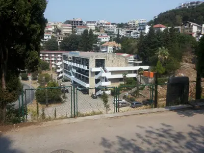 a building on a hill with a city in the background at Family House Milic in Ulcinj in Ulcinj