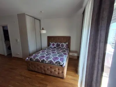 a bedroom with a bed with a purple comforter at Apartman City Kvart Podgorica in Podgorica