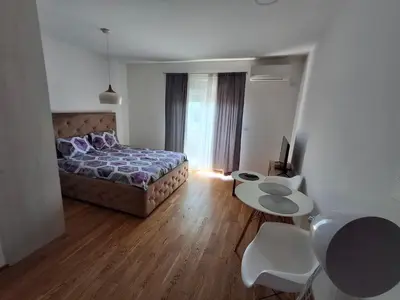 a bedroom with a bed and a table and chairs at Apartman City Kvart Podgorica in Podgorica